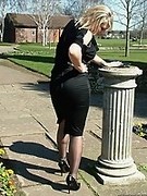 Gorgeous blonde MILF wearing a pretty black blouse and skirt, with matching pantyhose and tall stiletto heels