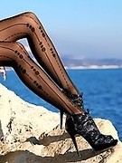 Long sexy legs in black patterned pantyhose and high heels outdoor teasing